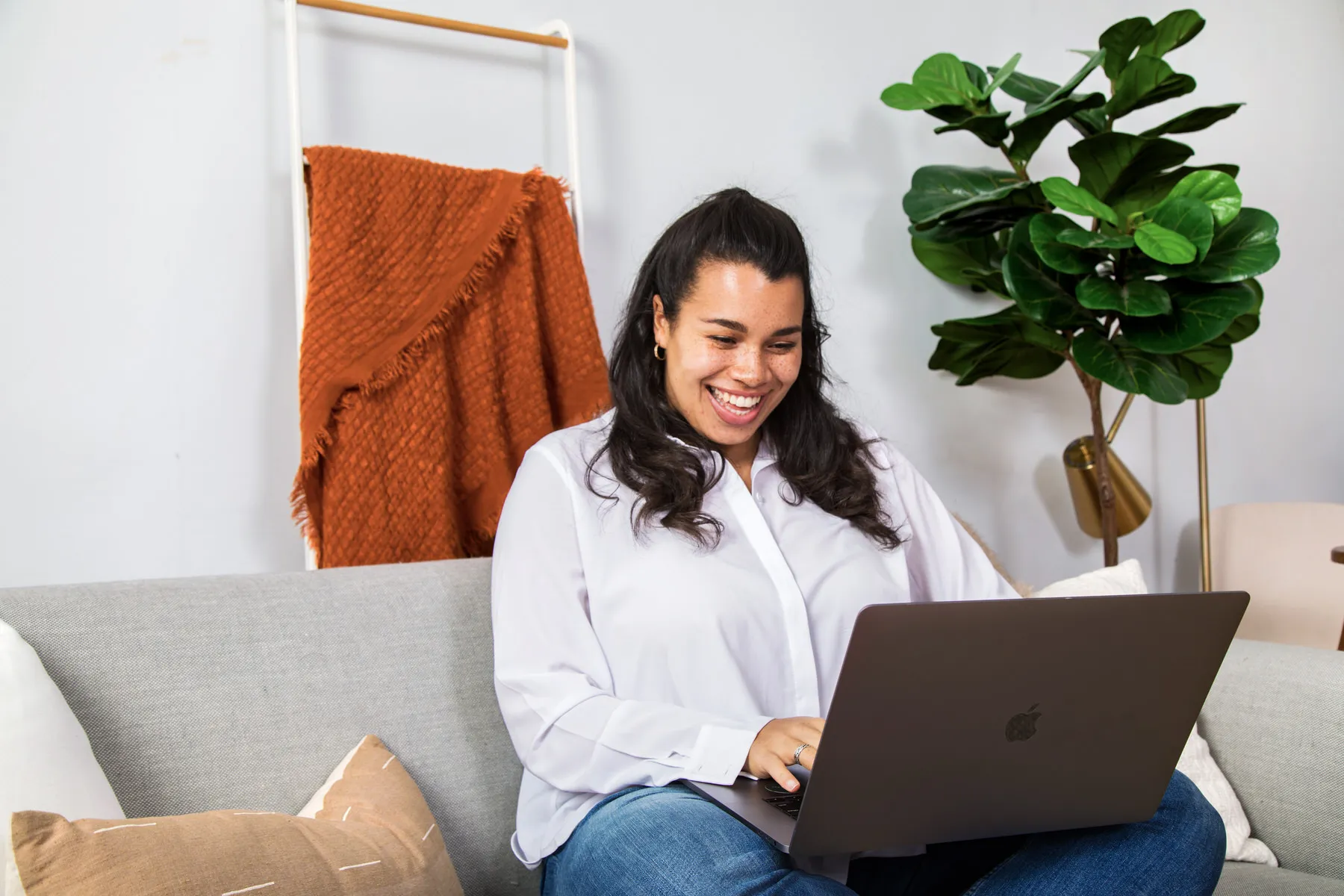 a woman working on the computer on their couch